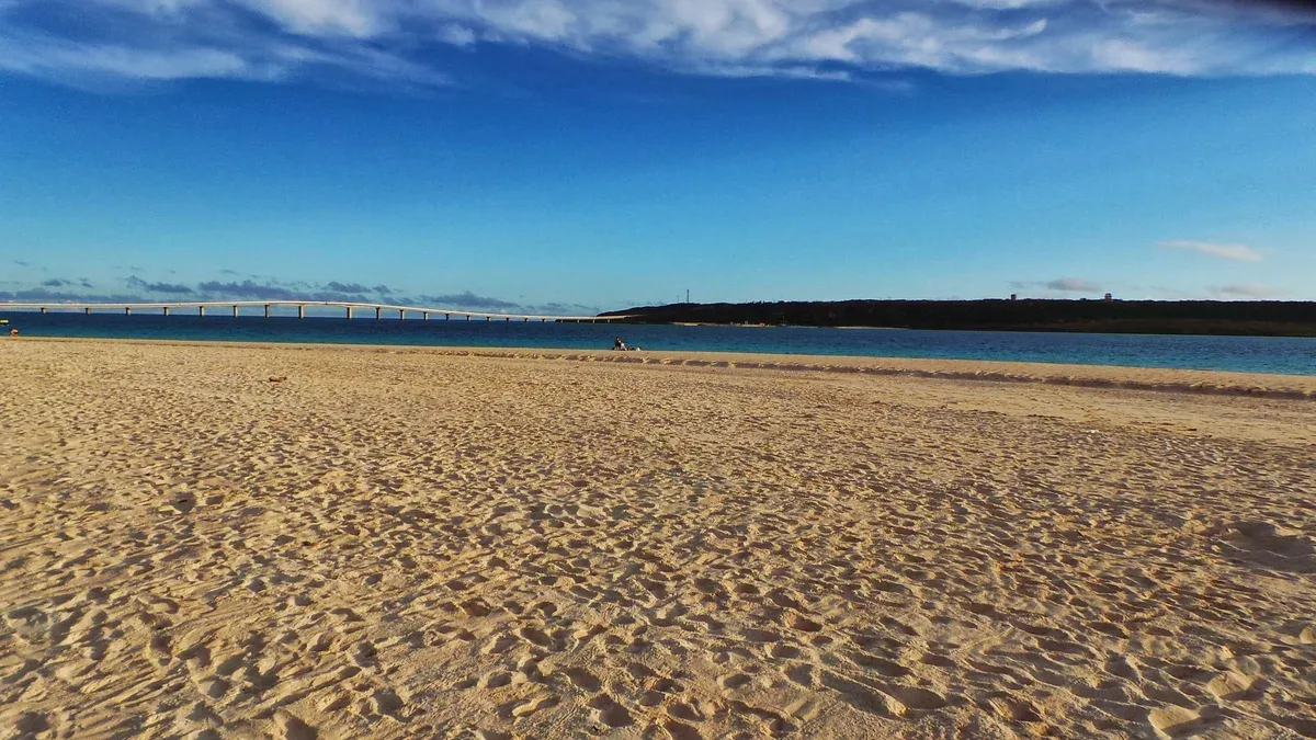 White sand beach with turquoise water and the Kurima Bridge on the Miyako Island sea turtle snorkeling tour coast